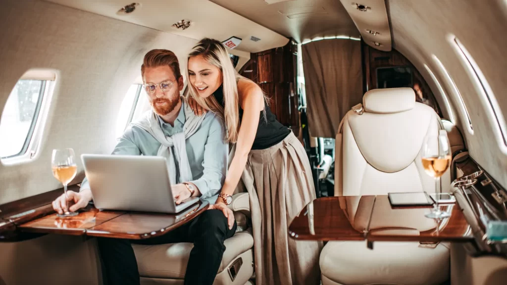Una coppia bougie su un jet privato scrivendo il loro blog di lifestyle. A bougie couple on a private jet writing their lifestyle blog.